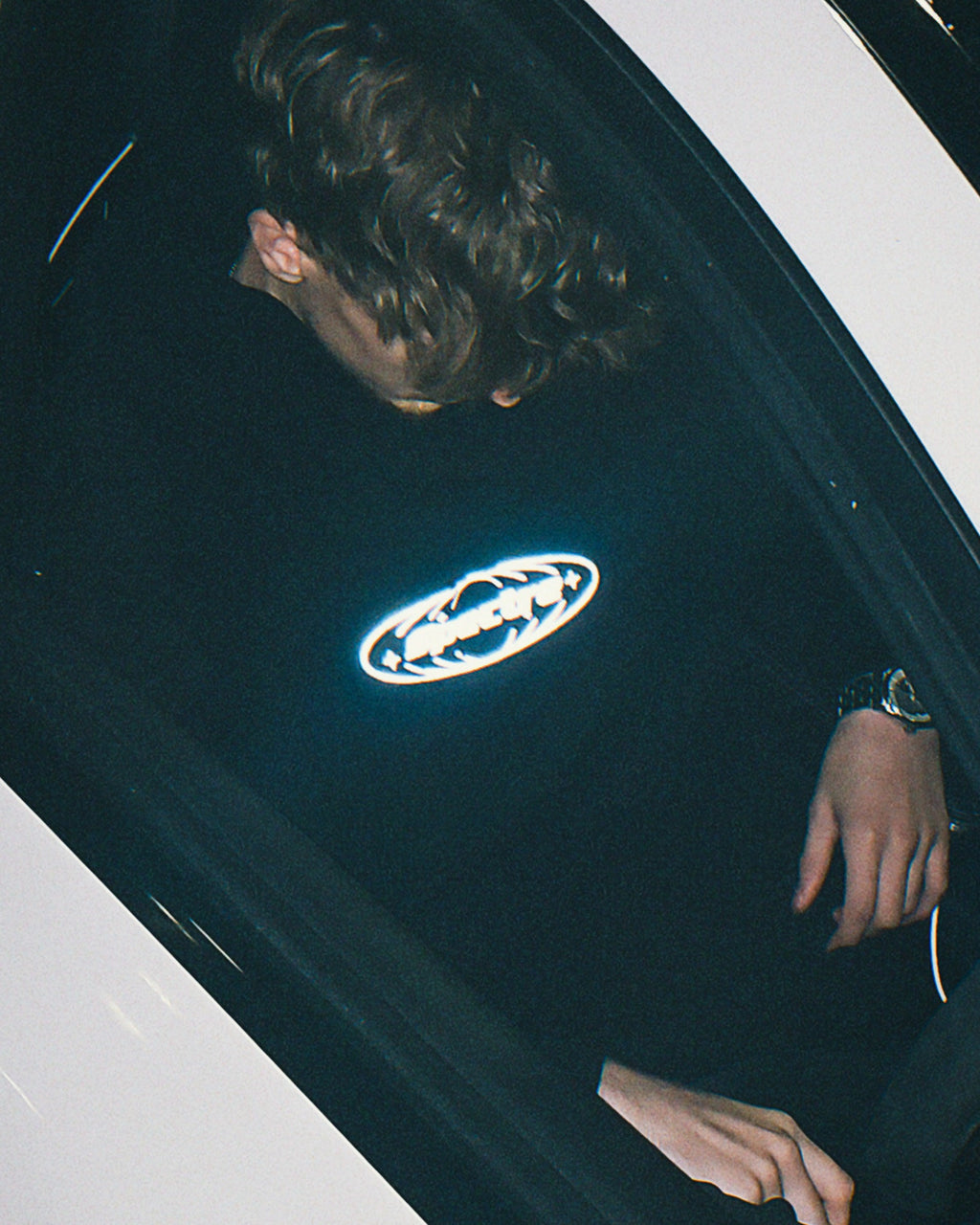 Person sat in a car with a visible brand logo on the chest.